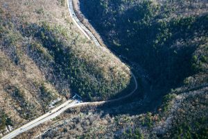 In 2017, two dozen federal, state, Tribal, and non-governmental organizations began collaborating as Safe Passage: The I-40 Pigeon River Gorge Wildlife Crossing Project. Their mission: To make 20 miles in North Carolina and eight miles in Tennessee more permeable for wildlife and safer for drivers. Interstate 40 sees more than 29,000 vehicles per day between Asheville, North Carolina, and Knoxville, Tennessee. Aerial view of the Pigeon River Gorge by Angeli Wright.