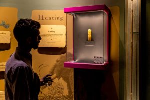 A visitor views work by contemporary artist Luzene Hill (Eastern Band of Cherokee Indians) in MCI’s permanent exhibition at the Disruption opening. Image courtesy of the Museum of the Cherokee Indian.