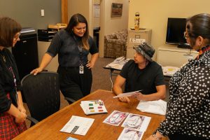 A Museum of the Cherokee People rebranding meeting includes, from left to right, Manager of External Affairs and Communications Anna Chandler, Director of Education Dakota Brown (Eastern Band of Cherokee Indians), artist and founder of Buffalotown Clothing Luke Swimmer (Eastern Band of Cherokee Indians), and Designer Tyra Maney (Eastern Band of Cherokee Indians, Diné). Maney conceptualized and executed the museum’s full in-house visual rebrand, which launched on Indigenous Peoples’ Day, October 9. Image courtesy Museum of the Cherokee People.