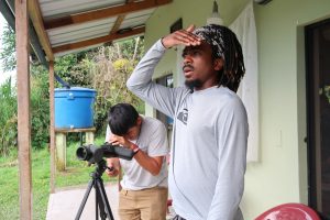 From the front porch of Wildsumaco Biological Station, Justin V. Bartolon trains a spotting scope on a Neotropical bird while Jameel Montgomery scans the horizon. They were two of ten students taking the course Comparative Temperate–Tropical Ecology and Biogeography, offered in July by Highlands Biological Station of Western Carolina University and Wildsumaco Biological Station of Francis Marion University. Photo by Frances Figart, provided by Smokies Life.