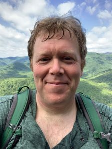 Ron Sutherland, chief scientist for Wildlands Network, stands atop Looking Glass Rock with the unbroken landscape of the Pisgah National Forest spreading out behind him. Photo provided by Ron Sutherland.