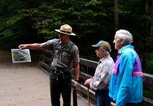 Holding a photo of the Cherokee dusky salamander, a recently discovered species, Seasonal Interpretive Ranger Cody Boettner discusses aquatic biodiversity in Great Smoky Mountains National Park and its status as the salamander capital of the world. Photo by Holly Kays, courtesy of Smokies Life. 