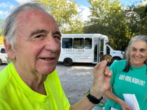 A participant in a Smokies Life monarch tagging event smiles while holding a tagged monarch as Wanda DeWaard looks on. Photo by André Brousseau, courtesy of Smokies Life. 