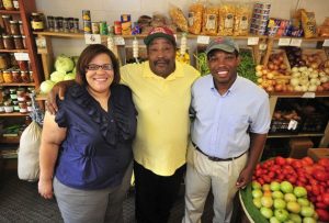 Latria Graham stands with her father and her brother at the family produce stand near Spartanburg, South Carolina. Photo courtesy of Latria Graham.
