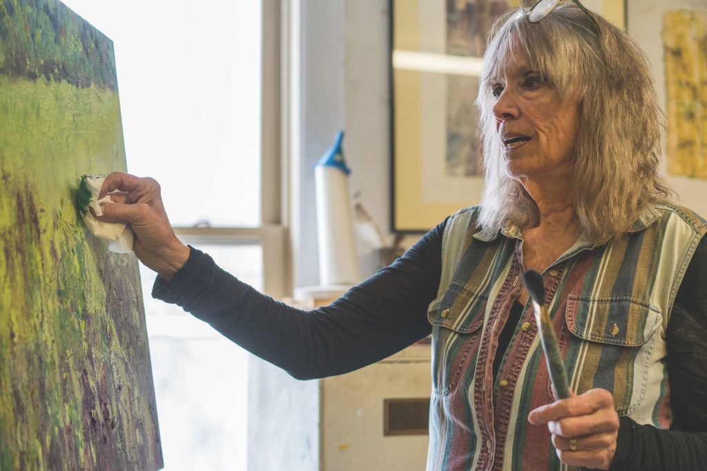 Elizabeth Ellison works on a painting in her second-floor studio along Main Street in Bryson City, her professional home since 1984. Photo by Quintin Ellison.
