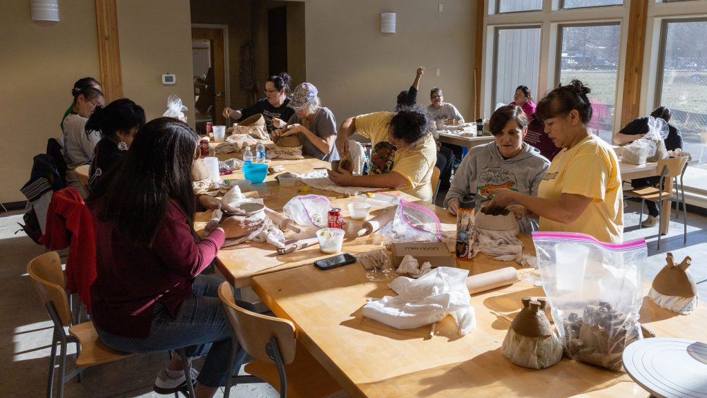 Tara McCoy (standing, far right) guides students during a Didanisisgi Gadawatli community pottery workshop. Photo courtesy of the Museum of the Cherokee People.