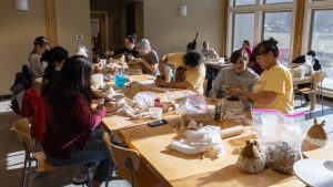 Tara McCoy (standing, far right) guides students during a Didanisisgi Gadawatli community pottery workshop. Photo courtesy of the Museum of the Cherokee People.