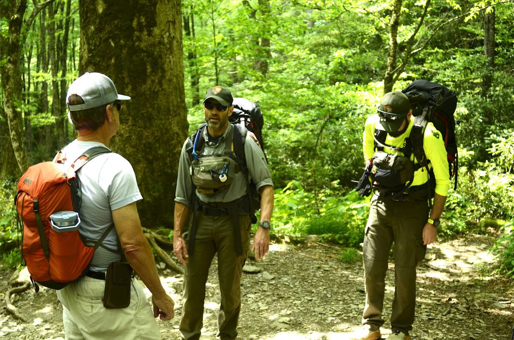 A hiker tells Supervisory PSAR Ranger Joshua Albritton and PSAR Ranger Cutter Wheeler about a woman further down the trail who may need help. Photo by Holly Kays, courtesy of Smokies Life.