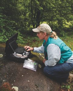 Lynn Faust uses a data logger to record ground temperature necessary for predicting peak firefly activity. Photo by Tom Uhlman, The Park Scientist, marykaycarson.com.