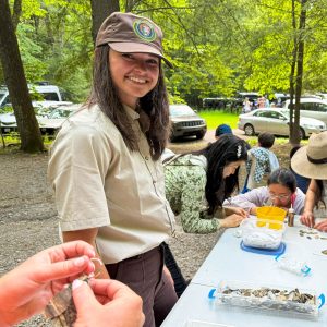 Wearing her Volunteer-In-Park uniform, Artist-in-Residence Claire Stovall interacts with park visitors during her residency in June. Photo by NPS. 