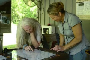 Two women leaning over a map. 