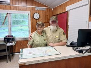 Two people in ranger uniforms standing behind a desk with a map on it.
