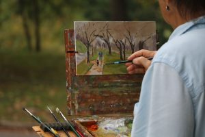A painting in the works of a forest scene.