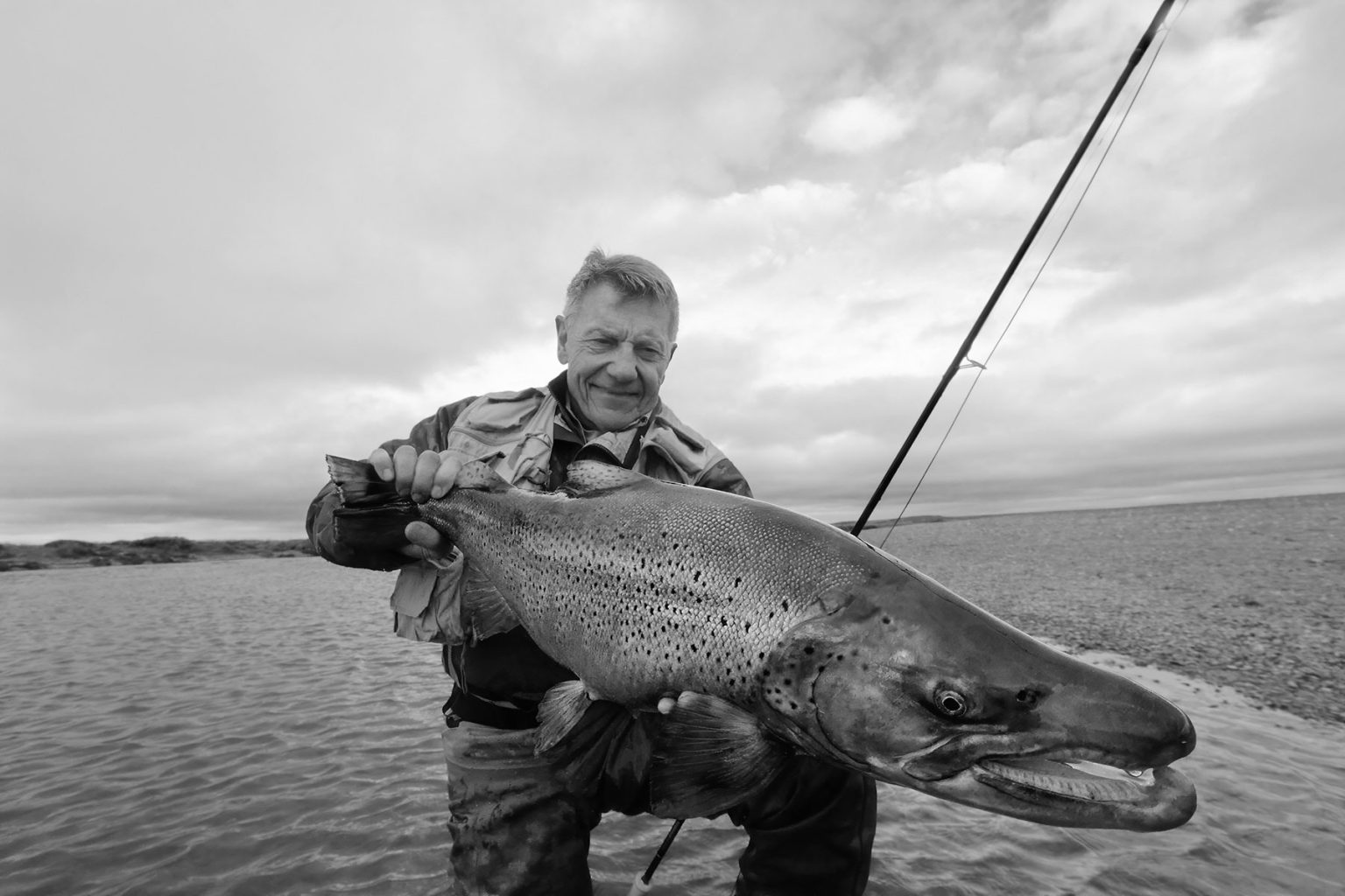 Black and white photo of a man holding a huge fish