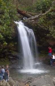 people standing around the base of a waterfall