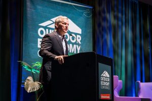 A man standing at a lectern speaking into a microphone.