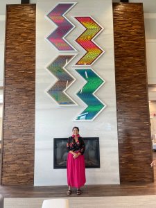 A woman standing in front of a large scale art installation