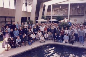 A group of people standing around a pool posing for a photo