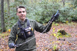 A male forest ranger holding a bear cable