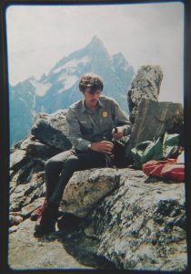 A man in a ranger uniform sitting on a rock