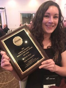 A smiling woman holding a plaque that reads 2016 North Carolina Media & the Law award Best series Holly Kays Smoky Mountain News