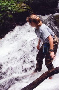 A woman standing on the edge of a waterfall