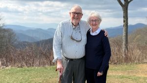 A man and woman both holding canes stand outside in the Smokies