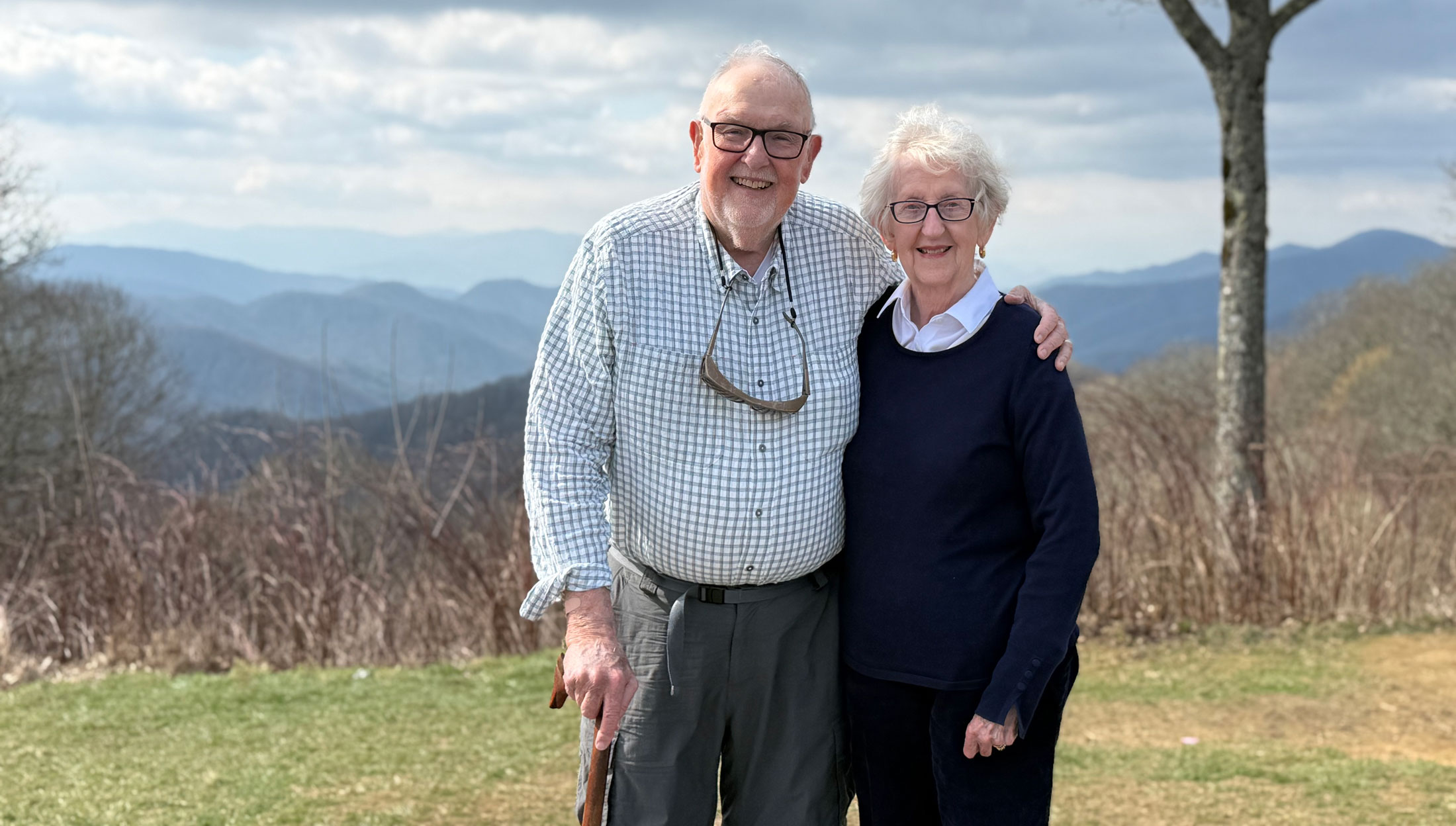 A man and woman both holding canes stand outside in the Smokies