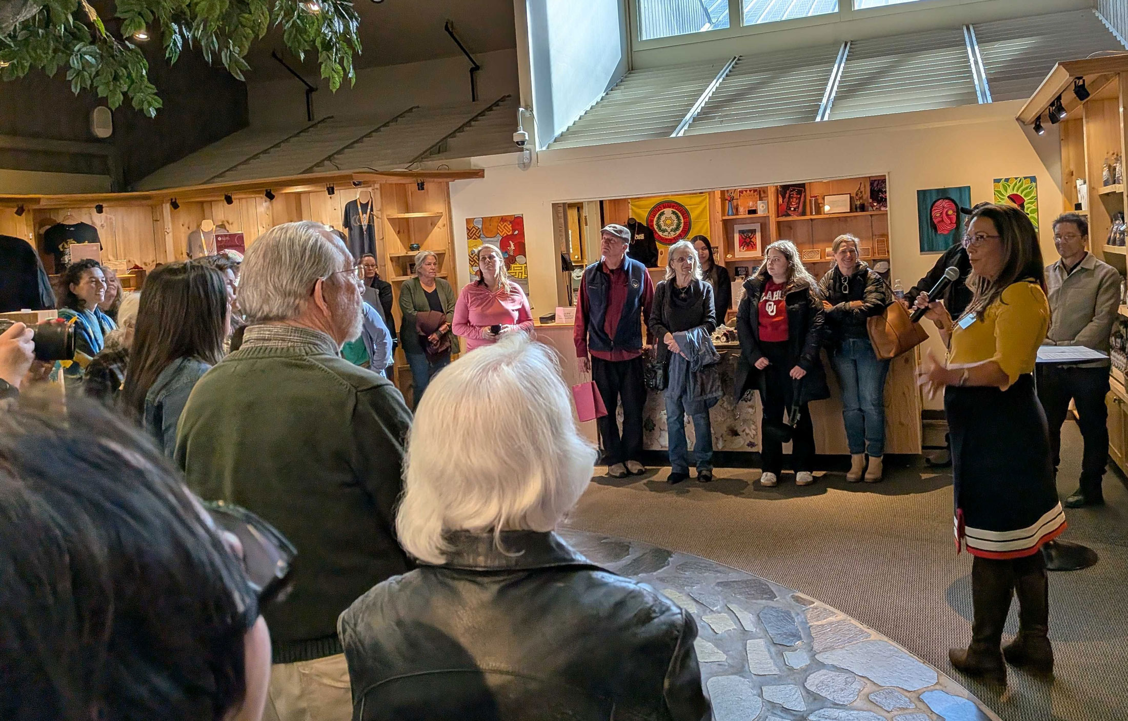 A woman speaks to a group of people at a museum exhibit
